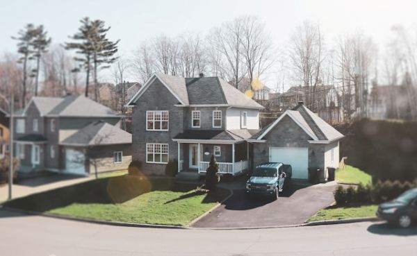 Car in driveway of a grey house 600 Unsplash
