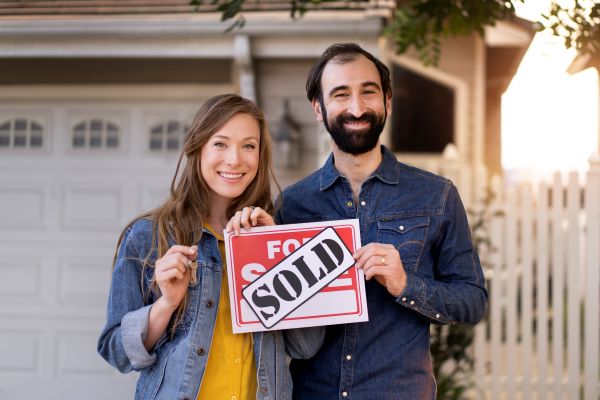 Couple holding sold sign 600 Freepik