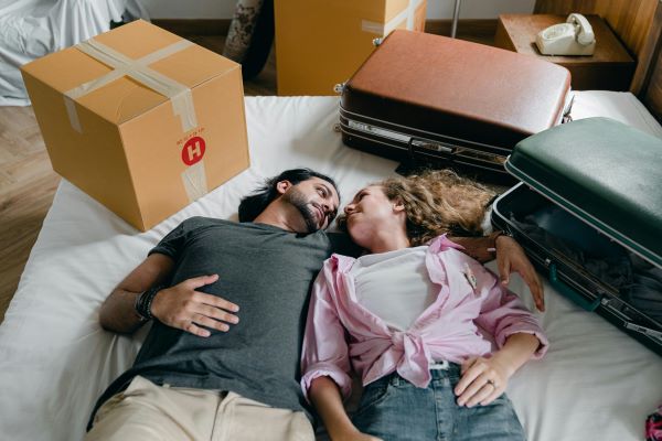 Couple on bed with suitcases 600 Pexels