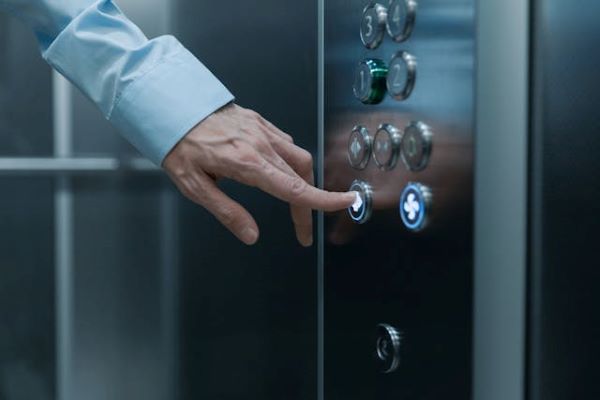 Hand pressing an elevator button 600 Pexels