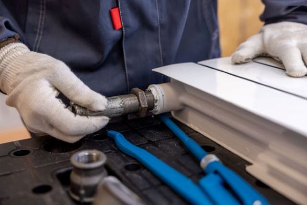 Plumber installing a radiator pipe 600 Pexels