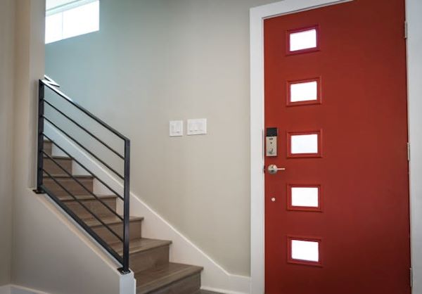 Red wooden door beside stairs 600 Pexels