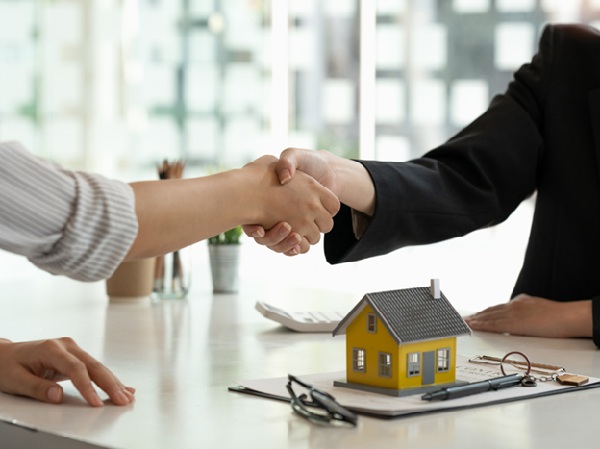 Shaking hands over a house 600 Canva