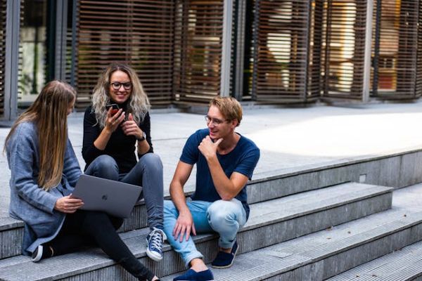 Three students sitting on steps with laptop 600 Pexels