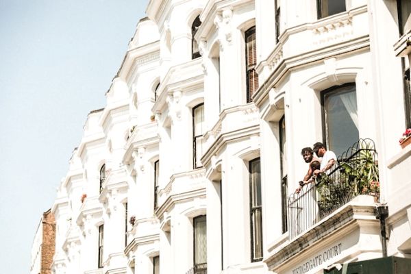 Two men and a child looking over a wrought iron balcony 600 Unsplash