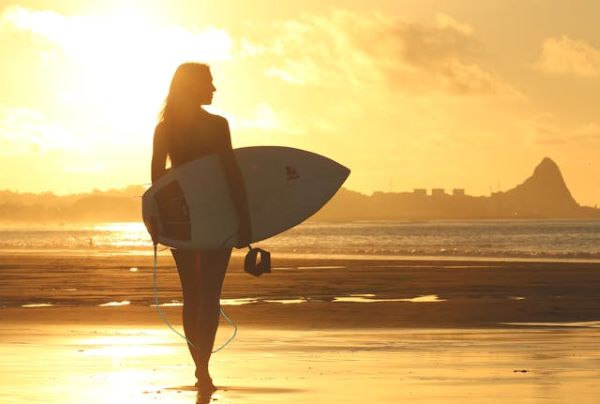Woman holding surfboard 600 Pexels