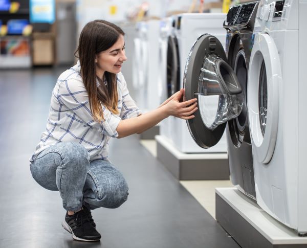 Woman looking at washing machine 600 Freepik