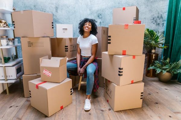 Woman sitting beside cardboard boxes 600 Pexels