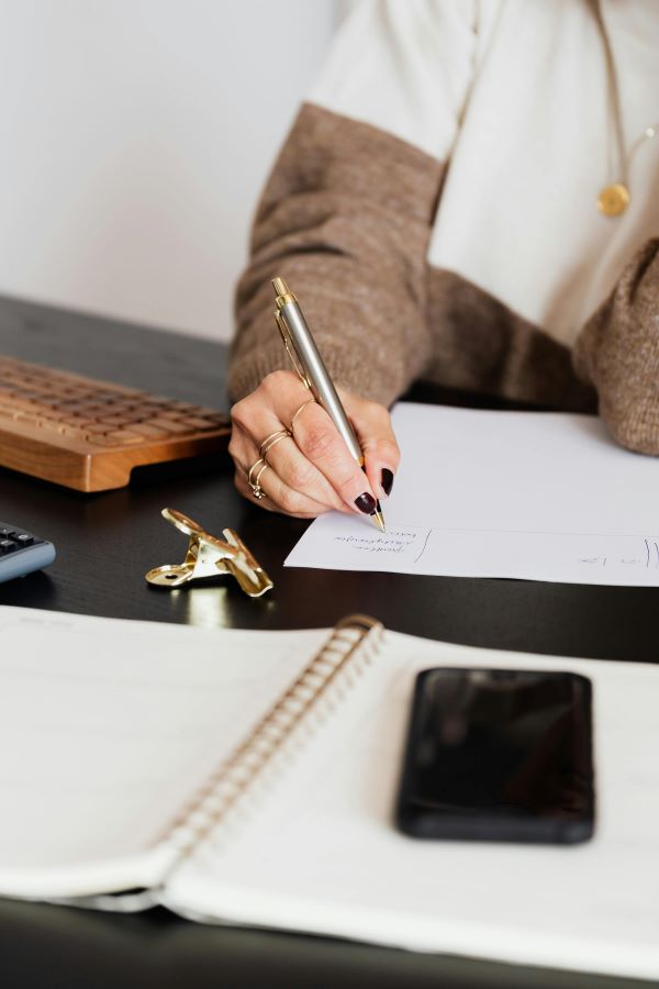 Woman writing at desk Pexels