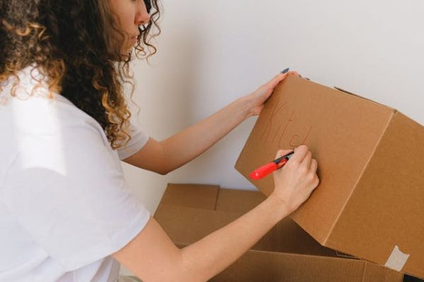 Woman writing on a box 600 Pexels