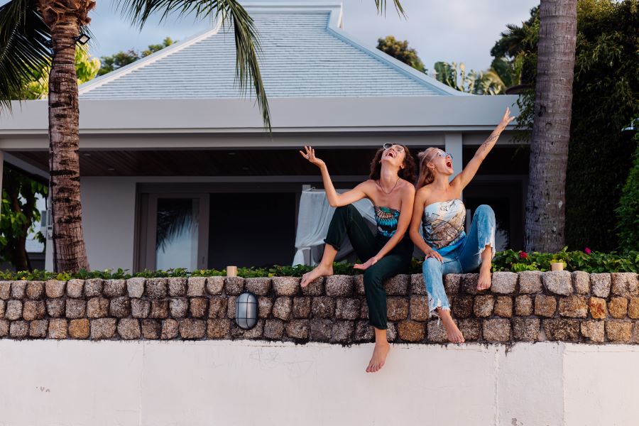 two happy woman friends with sunglasses vacation tropical country