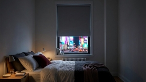 Blackout blinds can turn a neon-lit New York bedroom into a calm, sleep-friendly retreat.