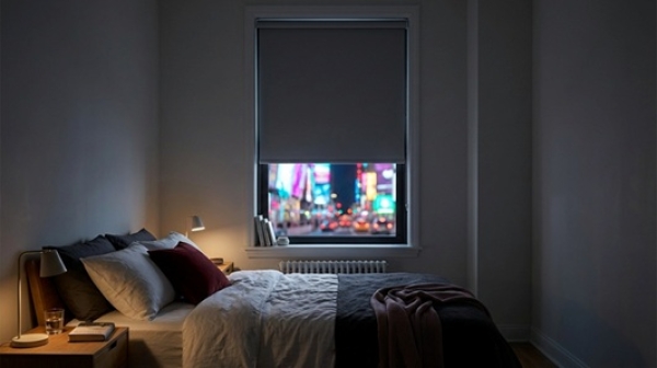 Blackout blinds can turn a neon-lit New York bedroom into a calm, sleep-friendly retreat.