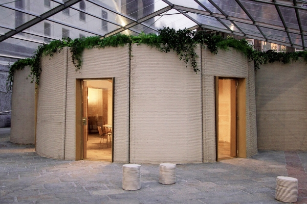 3D printed house unveiled in Milan. The one-story concrete house features curved walls and can be taken apart and reassembled elsewhere.
